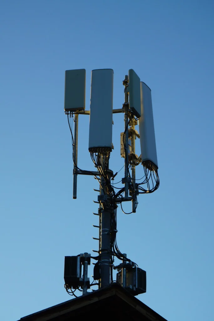Mobilfunk-Basisstation mit mehreren Antennen vor blauem Himmel - Mediatech Mobilfunk-Basisstation mit mehreren Antennen vor blauem Himmel